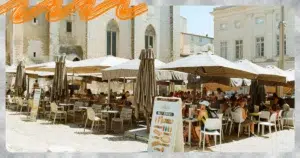 Terrasse animée d'un café devant le Palais des Papes à Avignon, illustration d'un séjour étudiant en stage ou alternance
