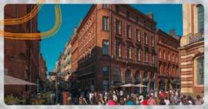 Façades en brique rose et passants au centre de Toulouse