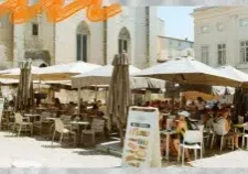 Terrasse animée d'un café devant le Palais des Papes à Avignon, illustration d'un séjour étudiant en stage ou alternance