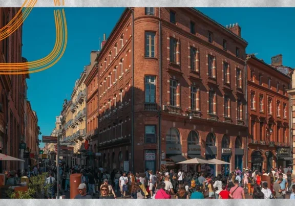 Façades en brique rose et passants au centre de Toulouse